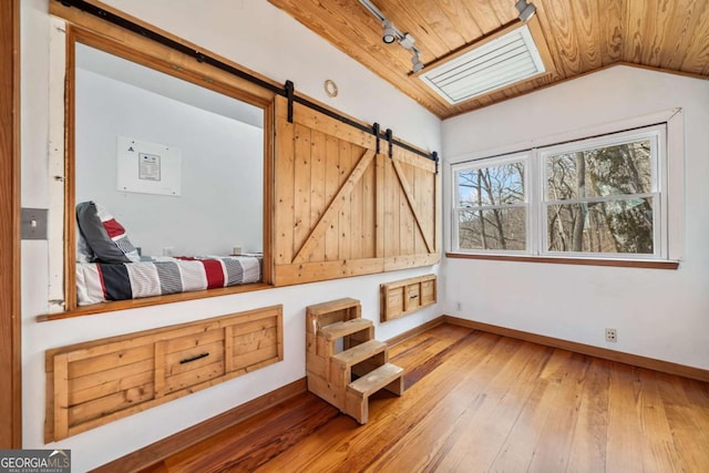 living area with lofted ceiling, track lighting, light wood-style flooring, and baseboards