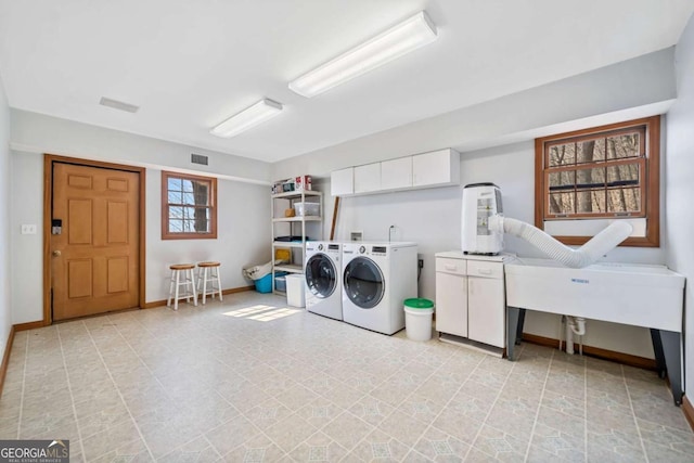 laundry area with cabinet space, baseboards, and washer and dryer