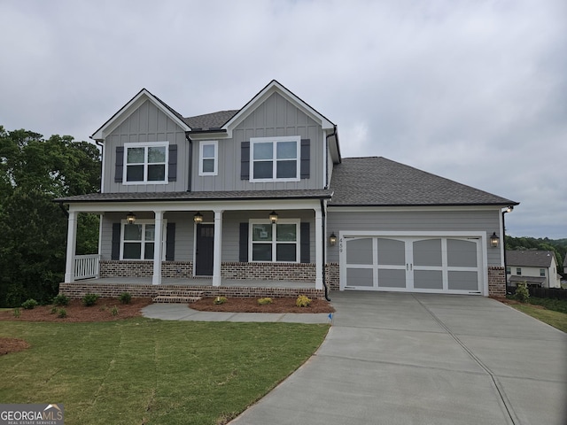 craftsman house featuring a porch, a front yard, a garage, driveway, and board and batten siding