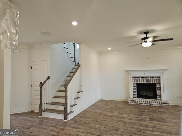 459 Banff Dr, Winder, GA 30680 - unfurnished living room featuring wood finished floors, ceiling fan, ornamental molding, stairs, and a brick fireplace