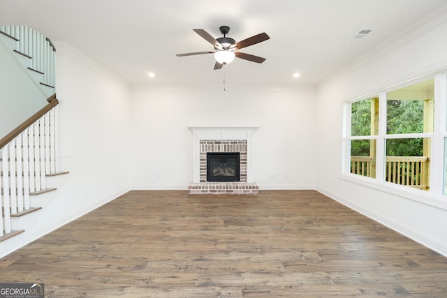 459 Banff Dr, Winder, GA 30680 - unfurnished living room featuring stairway, crown molding, a ceiling fan, wood finished floors, and a fireplace