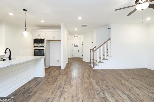 459 Banff Dr, Winder, GA 30680 - kitchen with appliances with stainless steel finishes, crown molding, ceiling fan, wood finished floors, and white cabinets