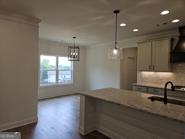 kitchen featuring light stone counters, tasteful backsplash, crown molding, visible vents, and baseboards
