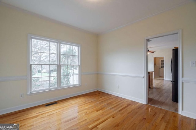 unfurnished room with visible vents, baseboards, and wood finished floors