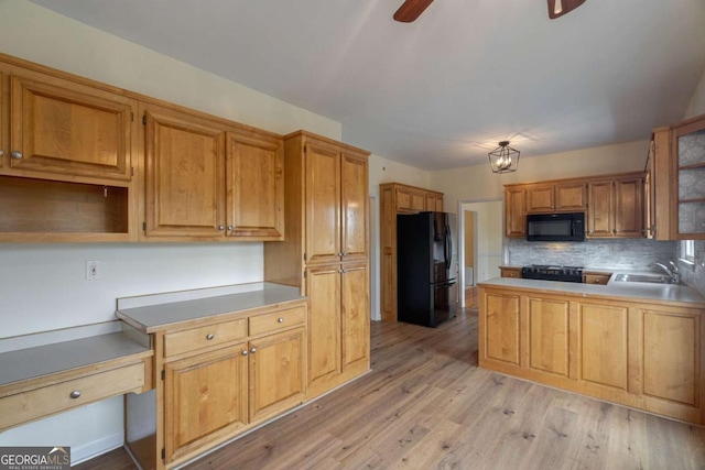 kitchen featuring light wood-style flooring, open shelves, backsplash, black appliances, and built in desk