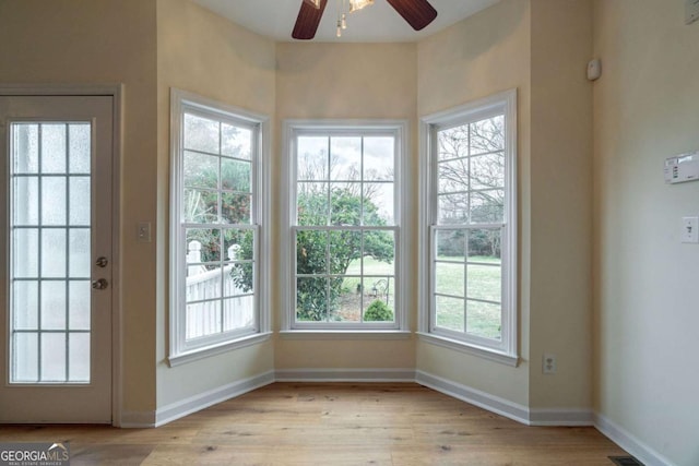 entryway featuring light wood finished floors, plenty of natural light, and baseboards