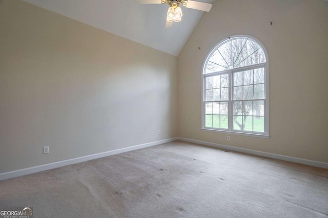 spare room with carpet floors, high vaulted ceiling, a ceiling fan, and baseboards