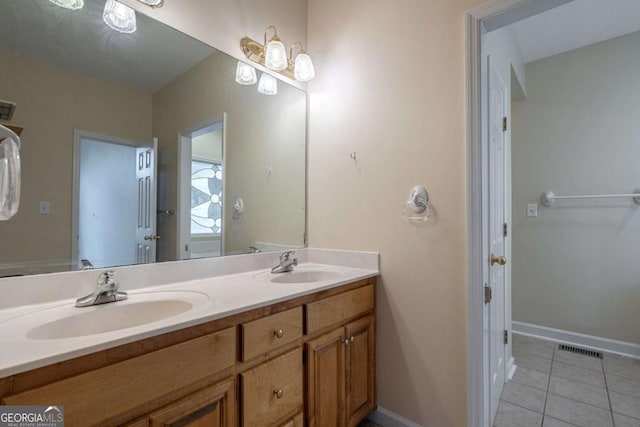 bathroom with double vanity, visible vents, a sink, and tile patterned floors