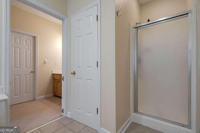 bathroom with a shower stall, vanity, baseboards, and tile patterned floors