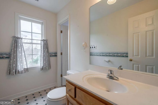 bathroom featuring tile patterned floors, vanity, toilet, and baseboards