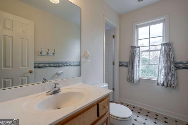 bathroom featuring toilet, tile patterned floors, baseboards, and vanity