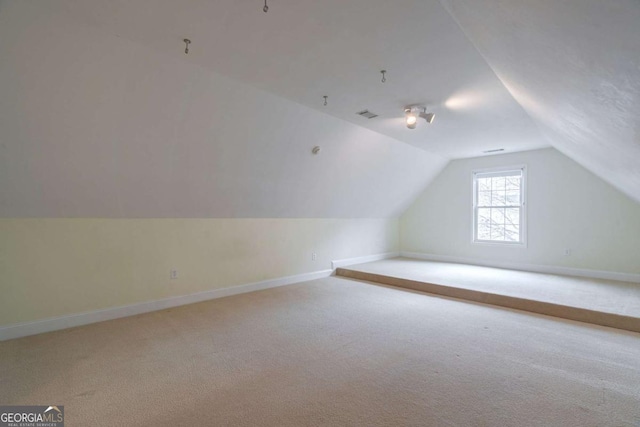 bonus room featuring lofted ceiling, visible vents, baseboards, and carpet flooring