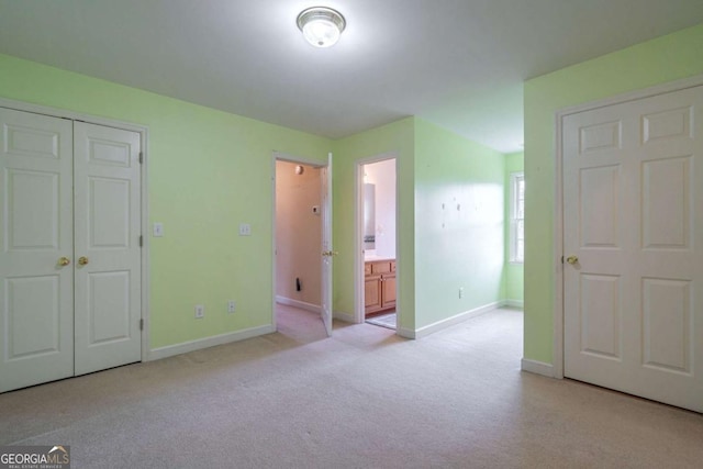 unfurnished bedroom featuring carpet, baseboards, and ensuite bathroom