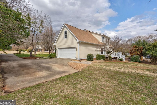 view of side of property featuring concrete driveway, a lawn, and an attached garage