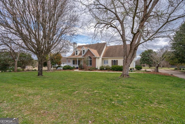 cape cod home with a chimney and a front yard