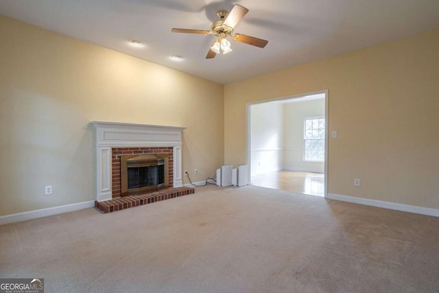 unfurnished living room with ceiling fan, a fireplace, baseboards, radiator heating unit, and carpet