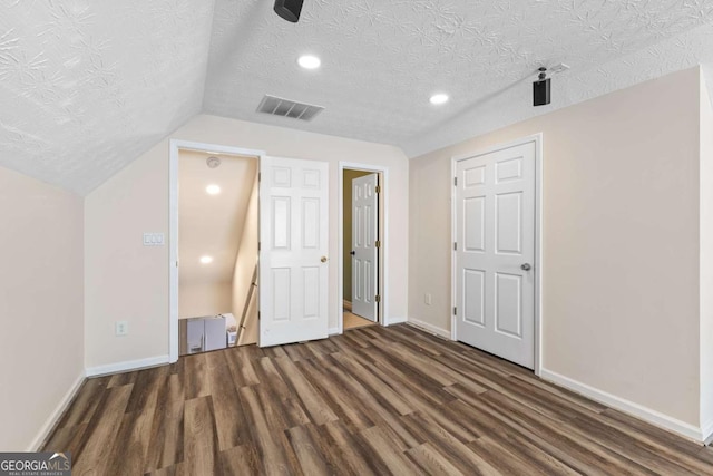 bonus room with visible vents, a textured ceiling, wood finished floors, baseboards, and vaulted ceiling