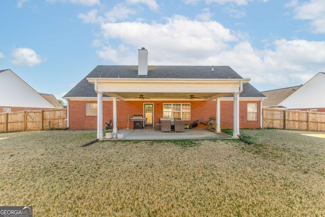 rear view of house featuring a patio, a chimney, a fenced backyard, and a ceiling fan