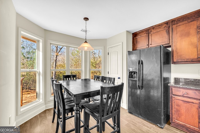 dining room with baseboards, visible vents, and light wood-style floors