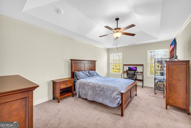 bedroom with a tray ceiling, light colored carpet, and baseboards