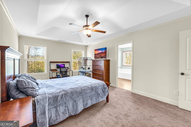 carpeted bedroom featuring crown molding, a raised ceiling, a ceiling fan, connected bathroom, and baseboards