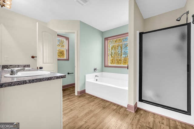 full bath with baseboards, a shower stall, a bath, and wood finished floors