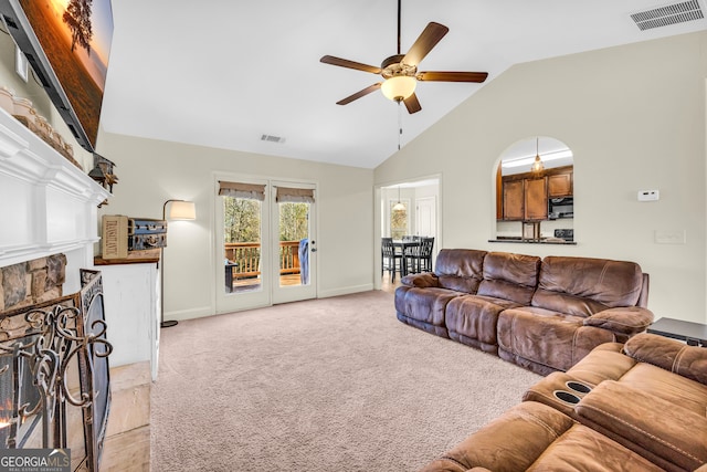 living area with visible vents, a fireplace, light carpet, and ceiling fan