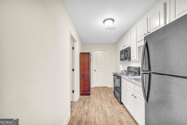 kitchen with visible vents, baseboards, white cabinets, black appliances, and light wood finished floors