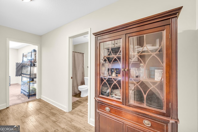 corridor with light wood finished floors and baseboards