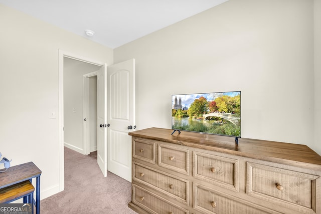 interior space featuring light colored carpet and baseboards