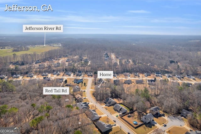 drone / aerial view featuring a forest view and a residential view