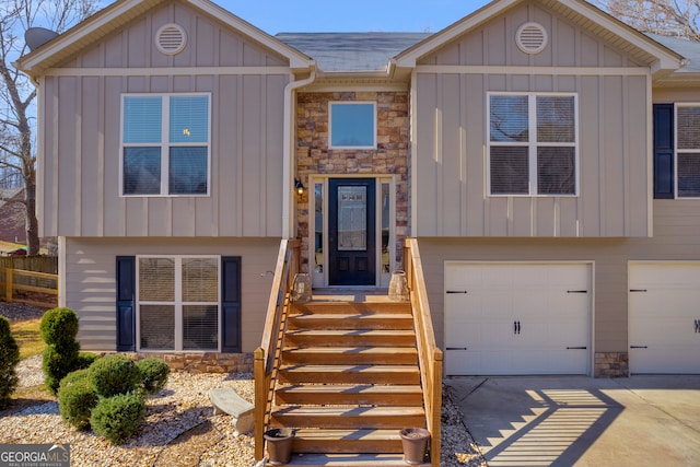 view of front of home with board and batten siding, stone siding, and driveway