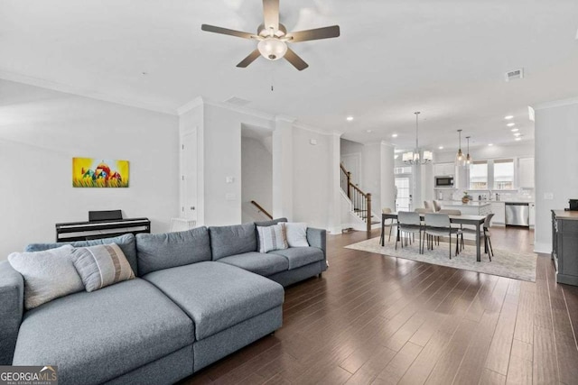 living area with recessed lighting, dark wood-style flooring, visible vents, stairway, and crown molding