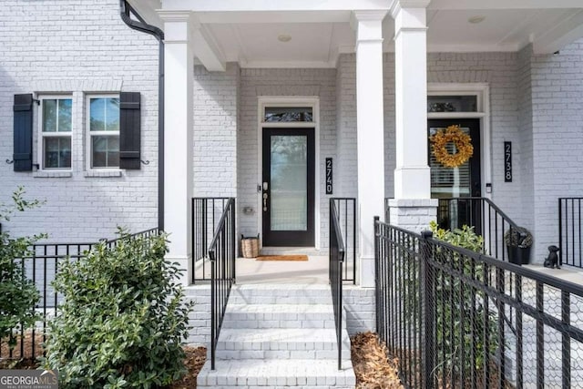 property entrance with fence and brick siding