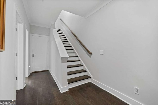 stairway featuring baseboards, wood finished floors, and ornamental molding