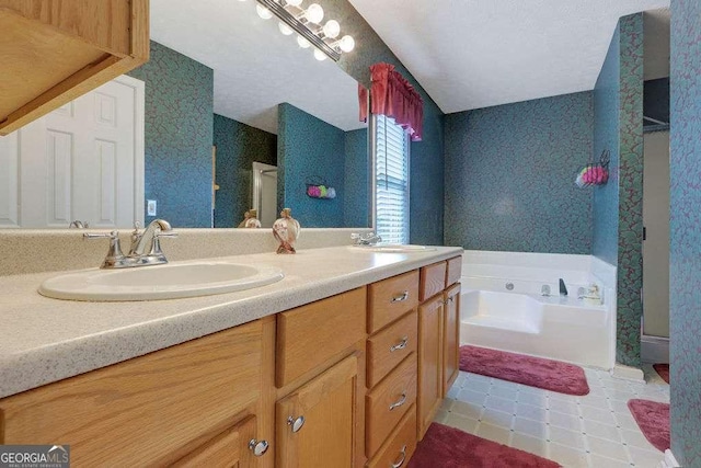 bathroom with a bath, wallpapered walls, double vanity, and a sink