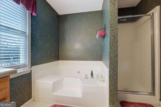 full bathroom featuring vanity, a shower stall, a bath, and wallpapered walls