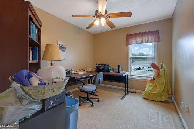 carpeted office space with ceiling fan and baseboards