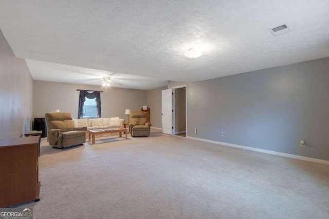 carpeted living room with visible vents, ceiling fan, a textured ceiling, and baseboards