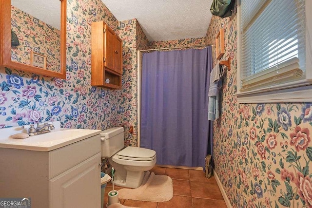 bathroom with wallpapered walls, toilet, tile patterned flooring, a textured ceiling, and vanity