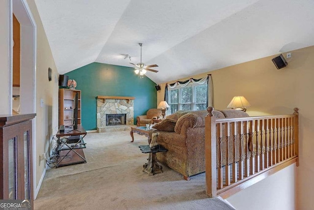 living room featuring lofted ceiling, carpet, a ceiling fan, and a stone fireplace