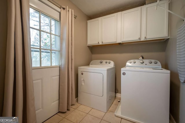 laundry area with cabinet space, washing machine and clothes dryer, and light tile patterned floors