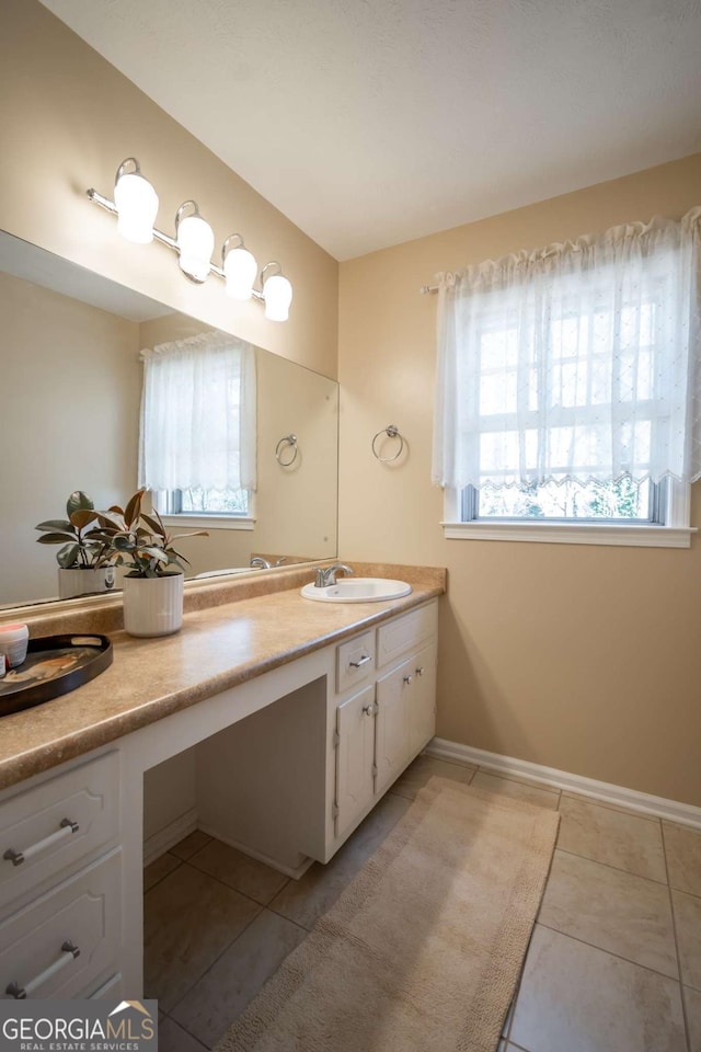 bathroom featuring tile patterned flooring, vanity, and baseboards