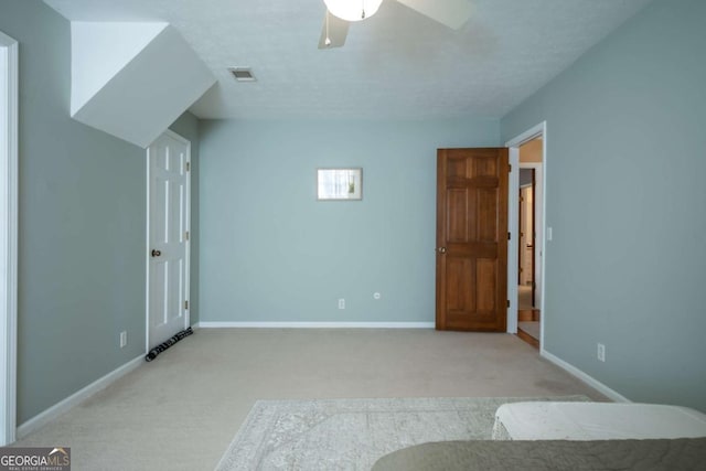 unfurnished bedroom featuring a ceiling fan, light colored carpet, visible vents, and baseboards