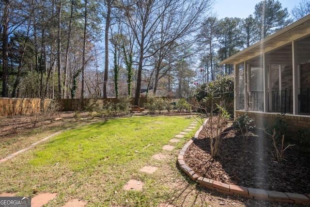 view of yard featuring a sunroom and fence