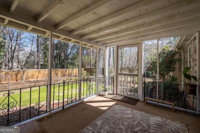 unfurnished sunroom with beamed ceiling