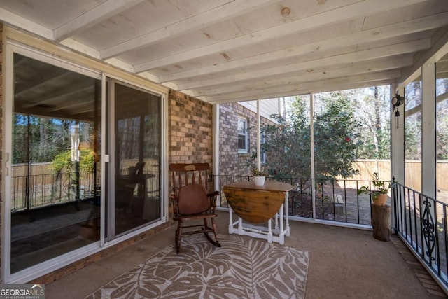 unfurnished sunroom featuring beam ceiling