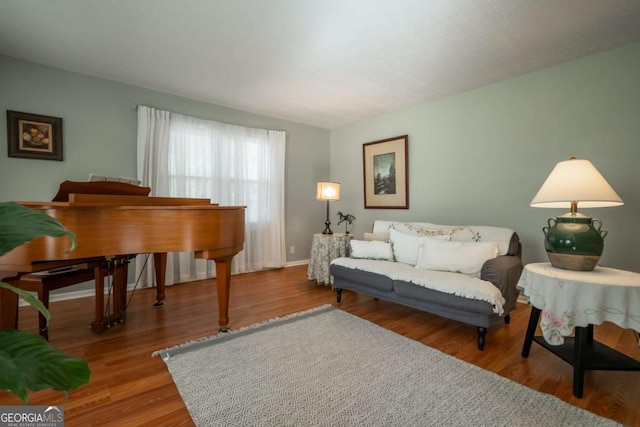 living area with baseboards and wood finished floors