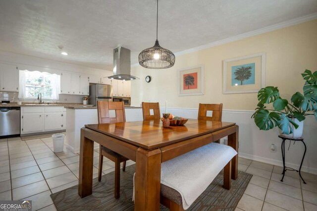 dining space featuring light tile patterned floors, baseboards, and ornamental molding