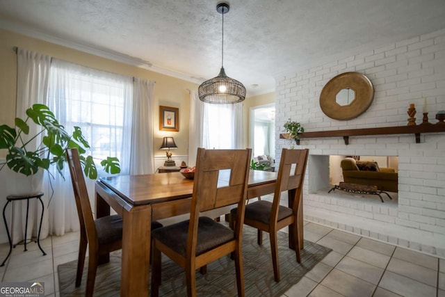 dining area featuring a wealth of natural light, a textured ceiling, and light tile patterned floors